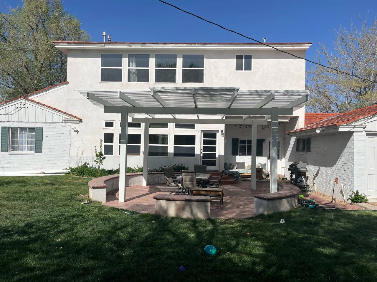 Wood-grain aluminum flat pan patio cover over a backyard patio in Rio Rancho