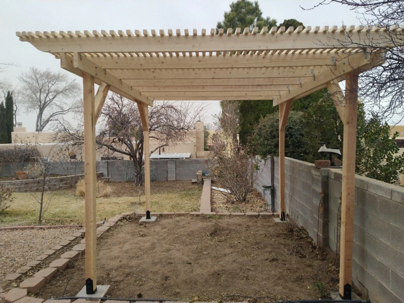 Stained wood pergola built over a backyard patio in Rio Rancho, NM