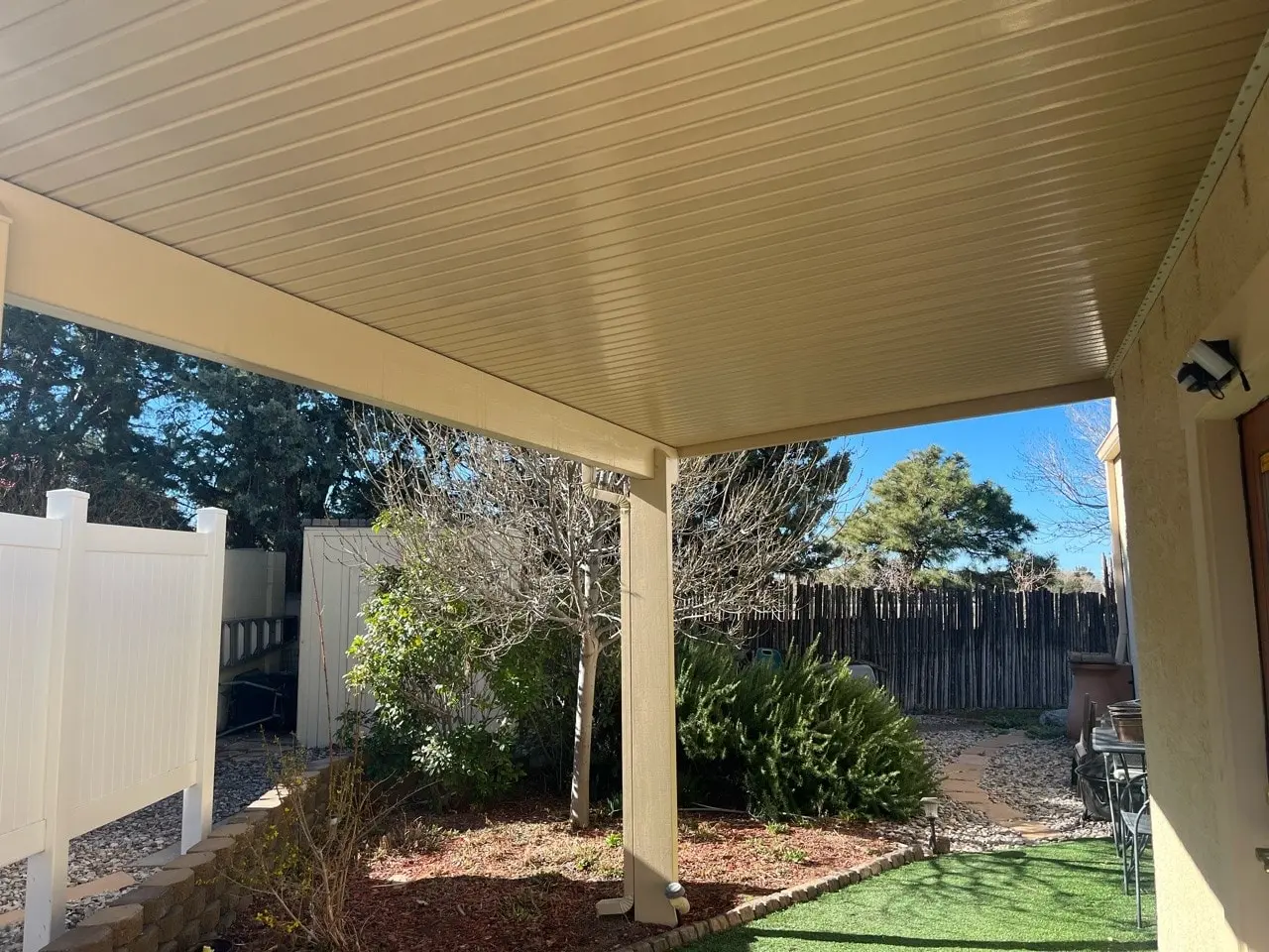 Attached aluminum patio cover extending shade across a New Mexico backyard